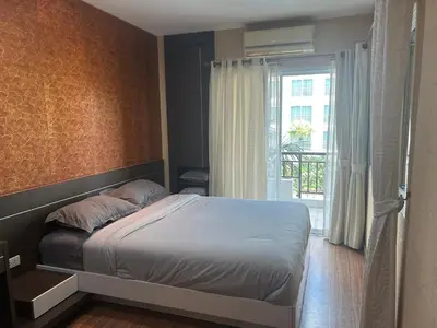 a bed in a bedroom with a large window at Phuket Villa Patong,Pool View in Patong Beach