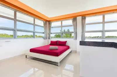 a bedroom with a red bed in a room with windows at Secluded Paradise Your Exclusive Villa Retreat V82 in Rawai Beach