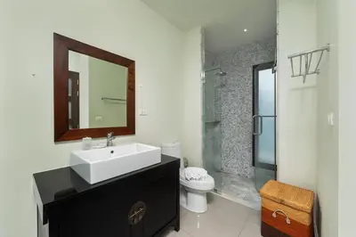 a bathroom with a sink and a toilet and a mirror at Villa Bulan with 3BR with Yoga house Nai Harn in Rawai Beach