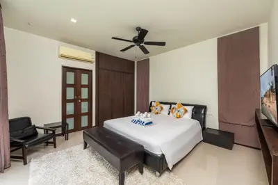 a bedroom with a bed and a ceiling fan at Villa Bulan with 3BR with Yoga house Nai Harn in Rawai Beach