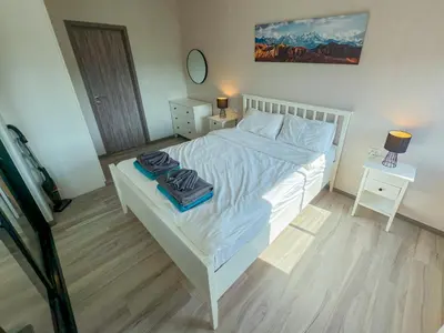 a bedroom with a white bed and a table with a lamp at The Title Residencies Naiyang by Mill in Nai Yang Beach