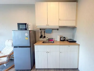 a small kitchen with a refrigerator and a sink at The Title Residencies Naiyang F by Mill in Nai Yang Beach