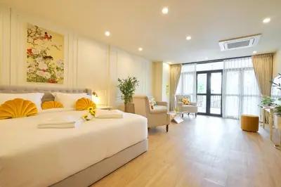 a bedroom with a large bed and a living room at Hawa House Phuket in Phuket Town