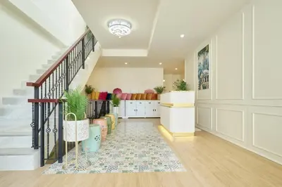 a hallway with a staircase with a rug and potted plants at Hawa House Phuket in Phuket Town