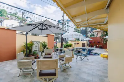 a patio with a table and chairs and umbrellas at Bauman-Ville Hotel Patong in Patong Beach