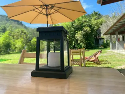 a lantern sitting on a table with an umbrella at Mukda in Ko Yao Noi