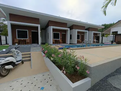 a house with a scooter parked in front of it at Hello Montri in Klong Muang Beach