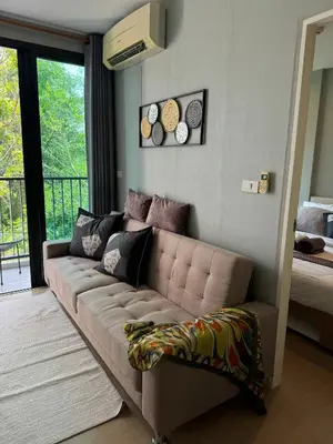 a living room with a couch and a balcony at Zcape X2 boat avenue by sahana in Bang Tao Beach