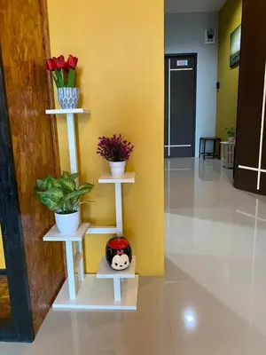 a room with two white shelves with plants and flowers at Maria's Guest House, Rawai in Rawai Beach