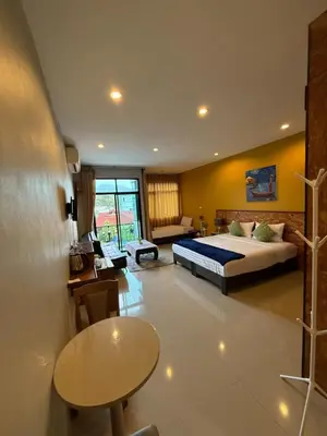 a bedroom with a bed and a table in a room at Maria's Guest House, Rawai in Rawai Beach