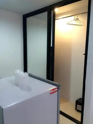a white refrigerator in a room with a mirror at The Seashore Kamala Service Apartment in Kamala Beach