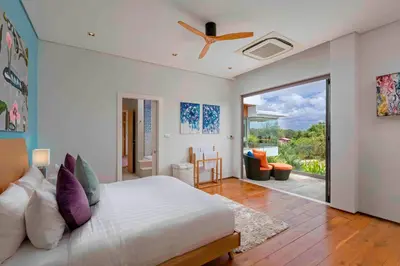 a bedroom with a bed and a ceiling fan at Villa White Skies in Khok Kloi