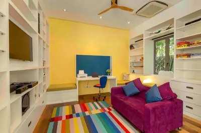 a living room with a purple couch and a desk at Villa White Skies in Khok Kloi
