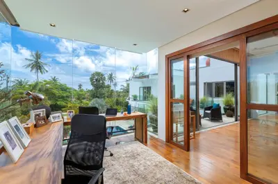 an office with a desk and a large glass wall at Villa White Skies in Khok Kloi