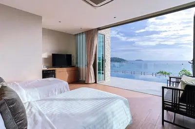 a bedroom with a large window with a view of the ocean at Villa W Collection in Nai Harn Beach