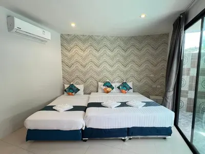 a bedroom with two beds and a window at Chanakarn Pool Access Rawai in Rawai Beach