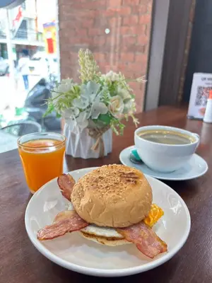a plate with a breakfast sandwich and bacon on a table at ZEN Hotel Patong Beach -ex- miami Production in Patong Beach