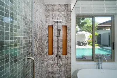 a bathroom with a tub and a sink and a mirror at Villa private swimming pool and garden in Phuket Town