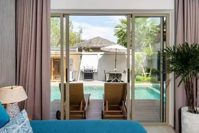 a living room with a view of a pool at Villa private swimming pool and garden in Phuket Town