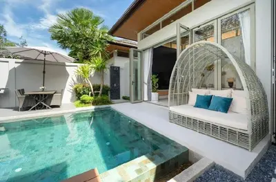 a villa with a swimming pool with a bed and an umbrella at Villa private swimming pool and garden in Phuket Town