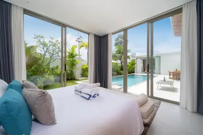 a bedroom with a large white bed and a pool at Luxury villa near Bangtao beach in Phuket Town
