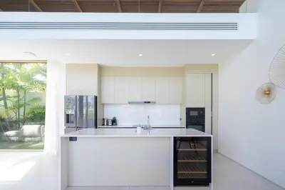 a kitchen with white cabinets and a kitchen island at Luxury villa near Bangtao beach in Phuket Town