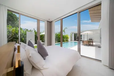 a bedroom with a white bed and a swimming pool at Luxury villa near Bangtao beach in Phuket Town