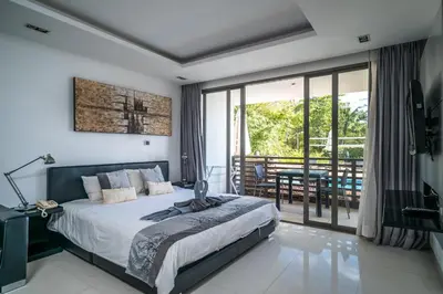 a bedroom with a bed and a balcony at Pool view studio at Nakalay Palm by Lofty in Kamala Beach