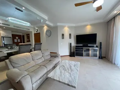 a living room with a couch and a flat screen tv at Allamanda Laguna 2 BR c выходом к бассейну in Phuket Town
