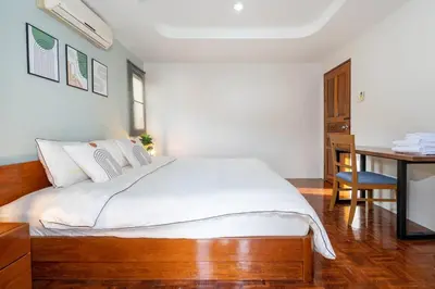 a bedroom with a large bed and a desk at Cozy Villa 4 Bedrooms Patong,7mins. walk beach/10mns.Bangla Rd in Patong Beach