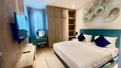 a bedroom with a bed with blue and white pillows at Kamala Falls Seaview 2 bedroom in Kamala Beach