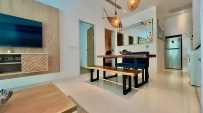 a living room with a table and blue chairs at Kamala Falls Seaview 2 bedroom in Kamala Beach