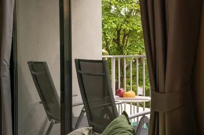a balcony with two chairs and a table with fruit on it at Title V Lemon Fresh Pool View Gym Hammam in Rawai Beach