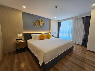a bedroom with a large bed with yellow pillows at Duplex in a 5 star hotel La Vita in Phuket Town