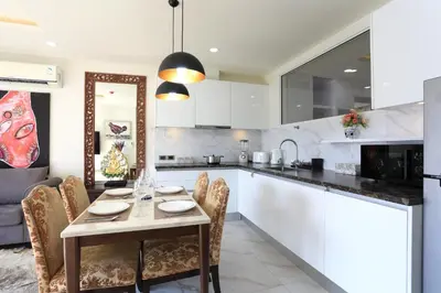 a kitchen with a table and chairs in a room at 2 bdr Apartment Calypso Garden NaiHarn Beach by Capital Pro CGC-310 in Rawai Beach