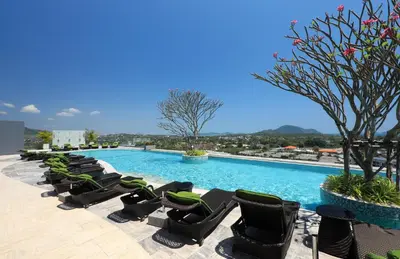 a row of lounge chairs next to a swimming pool at 2 bdr Apartment Calypso Garden NaiHarn Beach by Capital Pro CGC-310 in Rawai Beach