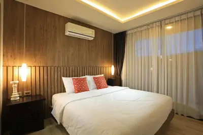a bedroom with a large white bed and a window at 2 bdr Apartment Calypso Garden NaiHarn Beach by Capital Pro CGC-310 in Rawai Beach