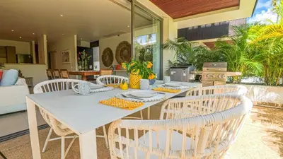 a dining room with a white table and chairs at Recently renovated 3BR apartment near Layan Beach in Phuket Town