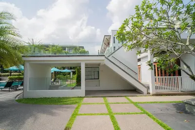 a house with a staircase on the side of it at Modern Beachfront Apartment Naithon Beach in Nai Thon Beach