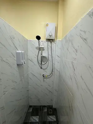 a bathroom with a shower with a phone on the wall at พัชรี รีสอร์ท ภูเก็ต Patcharee Resort Phuket in Phuket Town
