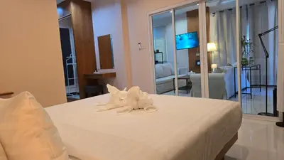 a white stuffed animal sitting on top of a bed at VK House Rawai, Phuket in Rawai Beach
