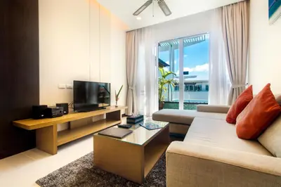 a living room with a couch and a tv at Krabi Luxury Penthouse in Klong Muang Beach