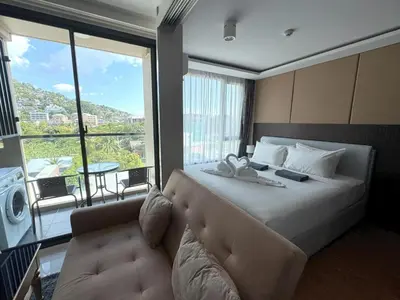 a bedroom with a large bed and a large window at Top floor apartment at Aristo by Lofty in Surin Beach