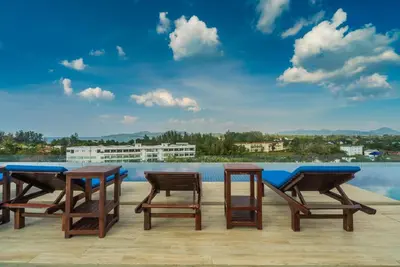 a group of four tables and chairs on a patio at Top floor apartment at Aristo by Lofty in Surin Beach