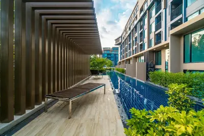 a bench sitting on the side of a building at Top floor apartment at Aristo by Lofty in Surin Beach