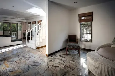 a living room with a staircase and a chair at Mountain View Villa Kamala in Kamala Beach