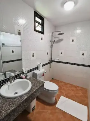 a bathroom with a sink and a toilet and a mirror at Kata beach townhouse in Kata Beach
