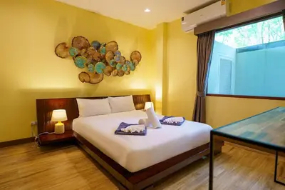 a bedroom with a bed with two towels on it at Blue Moon by G Estate Phuket in Ban Saiyuan (1)