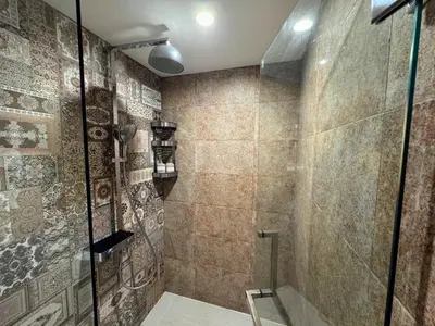 a bathroom with a shower with a glass door at The Title VH Rawai by Beringela in Phuket Town