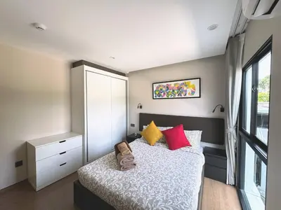 a bedroom with a bed with red and yellow pillows at The Title VH Rawai by Beringela in Phuket Town